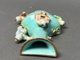 a figurine of a frog that is sitting on a table