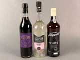 trois bouteilles d'alcool posées l'une à côté de l'autre sur une table