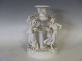 un vase blanc surmonté d'une statuette