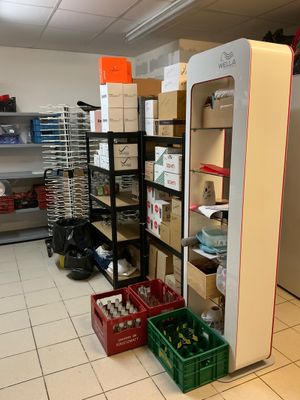 a refrigerator in the middle of a room with boxes on the floor