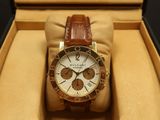 brown and white watch in a box on a black surface
