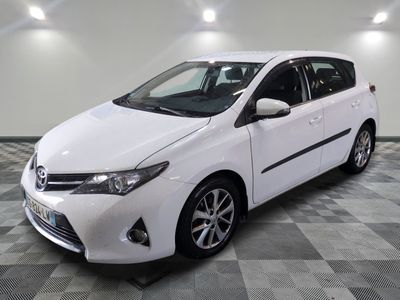 une photo d'une toyota yaris blanche garée sur un sol en damier