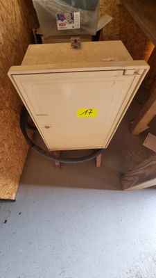 a small cabinet in the corner of a room with a lot of boxes