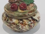 a small jar with cherries in it on a white surface