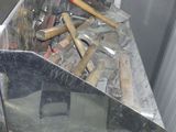 a pile of tools in a metal bin on the floor