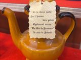 une théière jaune surmontée d'un oiseau