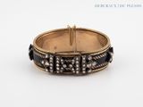 a close up of a bracelet on a white surface