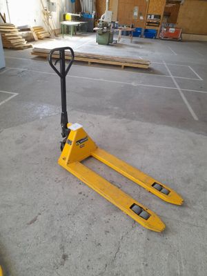 the forklift is sitting on the concrete floor in the warehouse