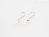 une paire de boucles d'oreilles en perles blanches sur fond blanc