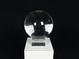 a glass ball sitting on top of a white pedestal