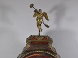 a clock that has a statue on top of it