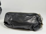 two pieces of black purses sitting on top of a white table