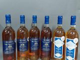 six bouteilles de vin sont alignées sur une table