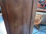 a tall wooden cabinet in the middle of a room