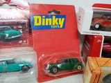 several toy cars are sitting on a table next to a box of boxes