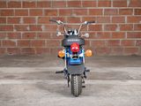 a small motorcycle parked in front of a brick wall