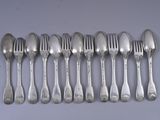 six spoons and six forks are lined up on a table