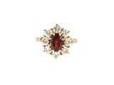 gros plan d'une bague avec une pierre rouge entourée de diamants blancs