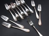 silver plated forks and spoons laid out on a black surface