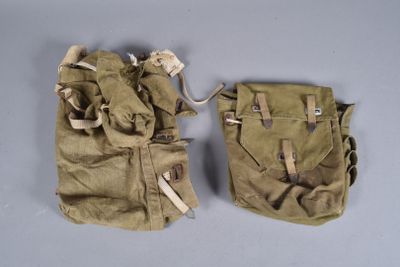 pair of old military pouchs on a table with one open and the other closed