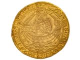 gros plan d'une pièce d'or sur une surface blanche
