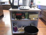une cafetière et une poubelle dans une pièce