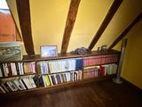 a bookshelf with a lot of books on it in the corner of a room