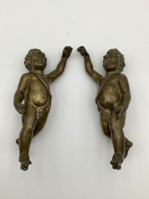 Paire d’angelots spéculaires en bronze.