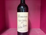 une bouteille de vin posée sur une étagère, dans une boîte rose