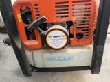 an orange and black chainsaw sitting on top of a cement floor