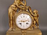 une horloge en or sur laquelle sont représentés une femme et un enfant
