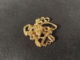 a close up of a gold necklace on a black surface