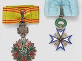 three medals are displayed on a white surface with a blue ribbon