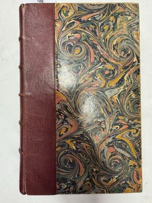 un vieux livre avec une couverture marron ornée d'un motif en spirale
