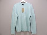 the light blue sweater is hanging on a hanger on the wall