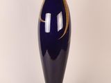 a blue vase with a gold decoration on it