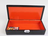 a black box with a red lid that has a chocolate bar in it