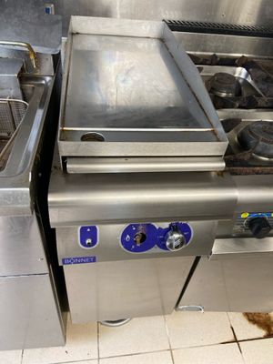 une plaque de cuisson en acier inoxydable sur laquelle est posée une poêle
