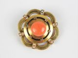une image représentant une broche aux couleurs or et corail sur fond blanc