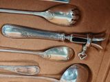 five spoons and a knife on a table