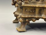 a bronze statue of a man sitting on top of a table