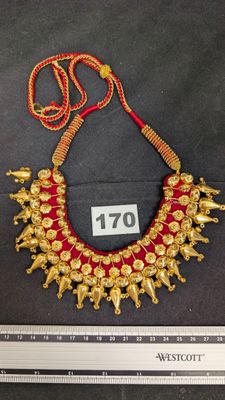 une photo d'un collier en or orné de perles rouges et dorées