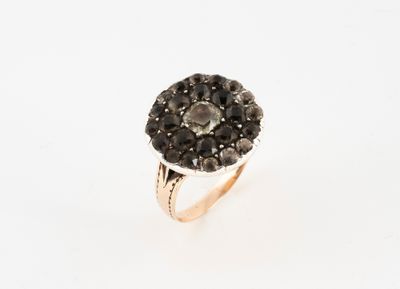 a close up of a ring with black diamonds on a white background
