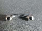 a silver nose ring with black stones on it