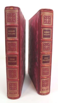 pair of antique red leather books with gold trims on them