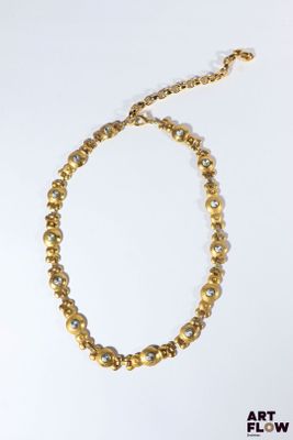 un gros plan d'un collier sur une surface blanche avec un fond blanc