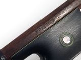 a close up of a violin bow on a white surface