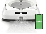 le robot asperge d'eau le sol à côté d'un téléphone