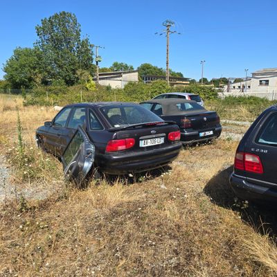 two cars parked next to each other on the side of the road