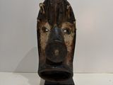 a wooden mask on display on a white table
